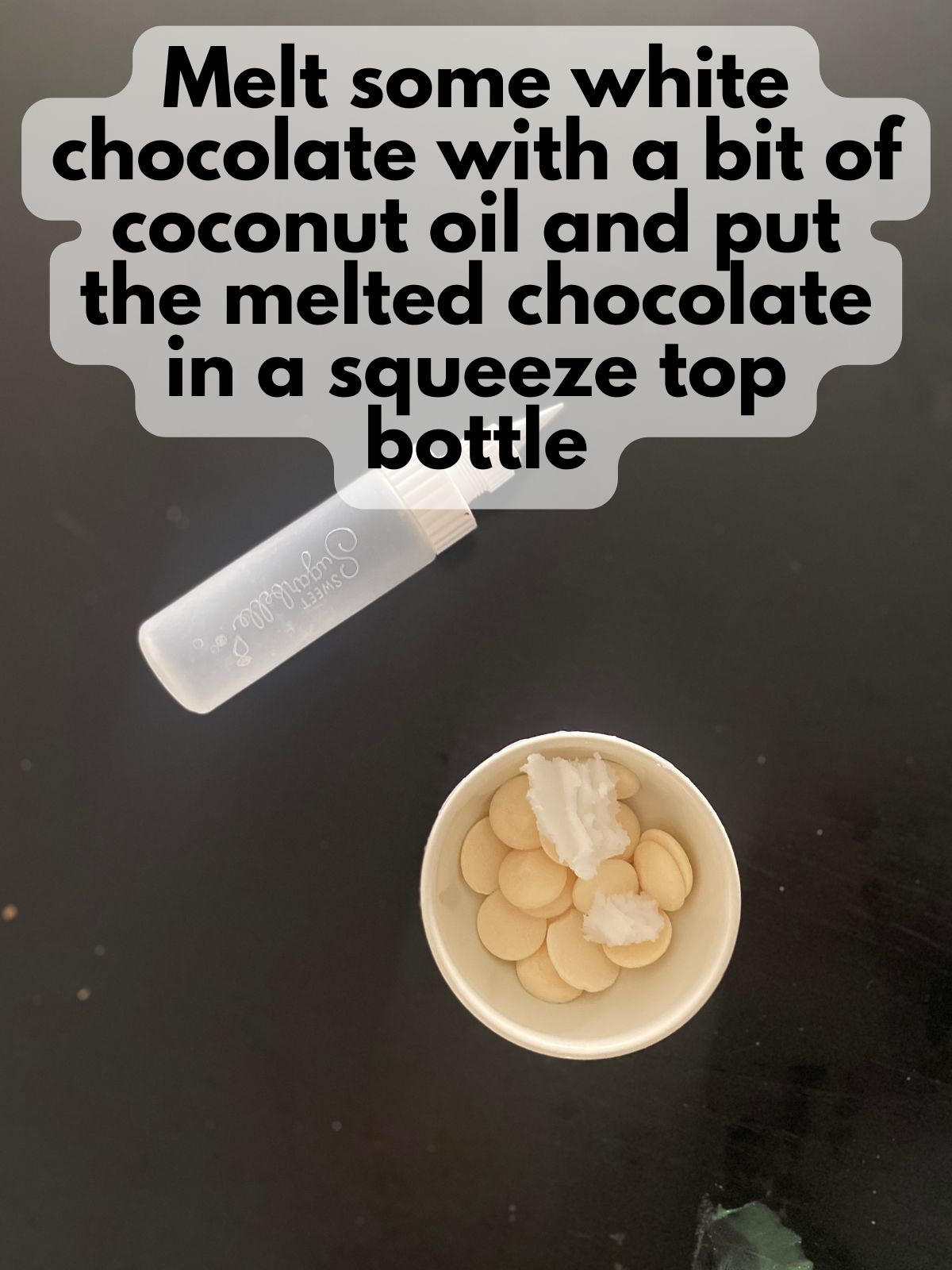 white candy melts in a bowl with some coconut oil and next to a small squeeze top bottle