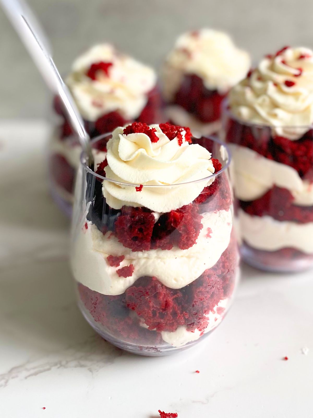 red velvet cheesecake parfait with a spoon sticking out of it