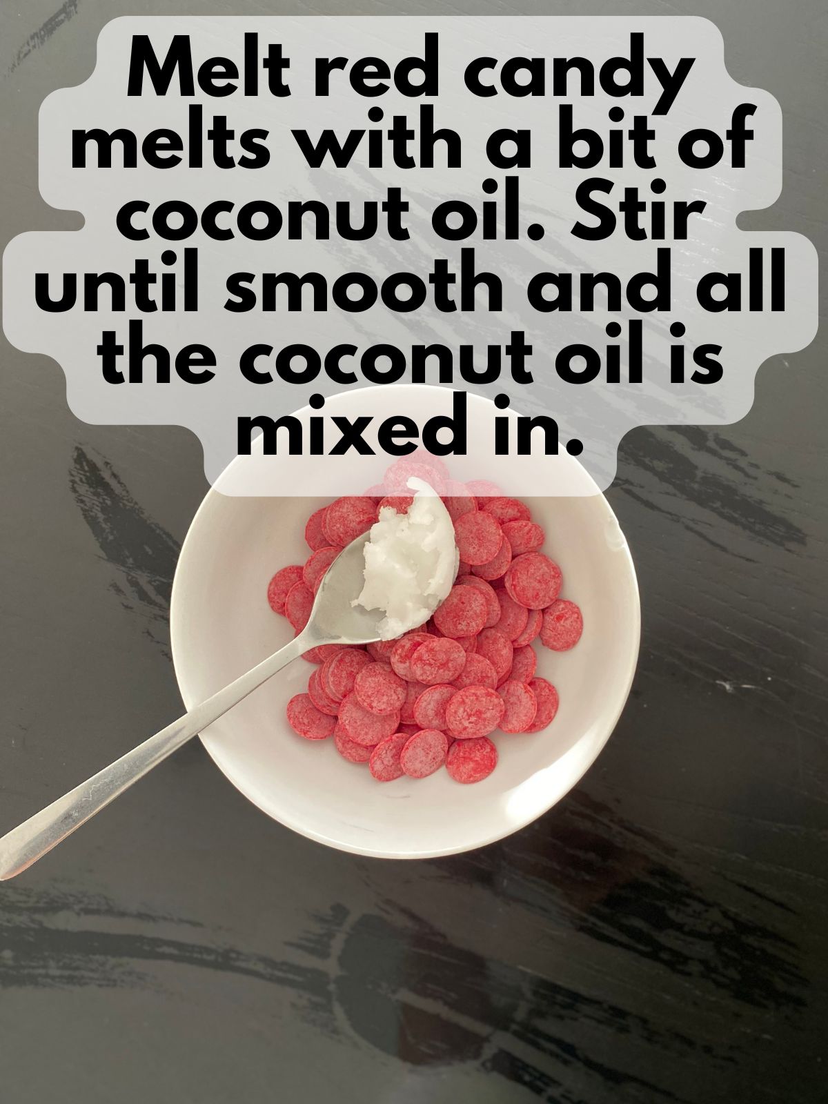 red candy melts in a bowl with some coconut oil