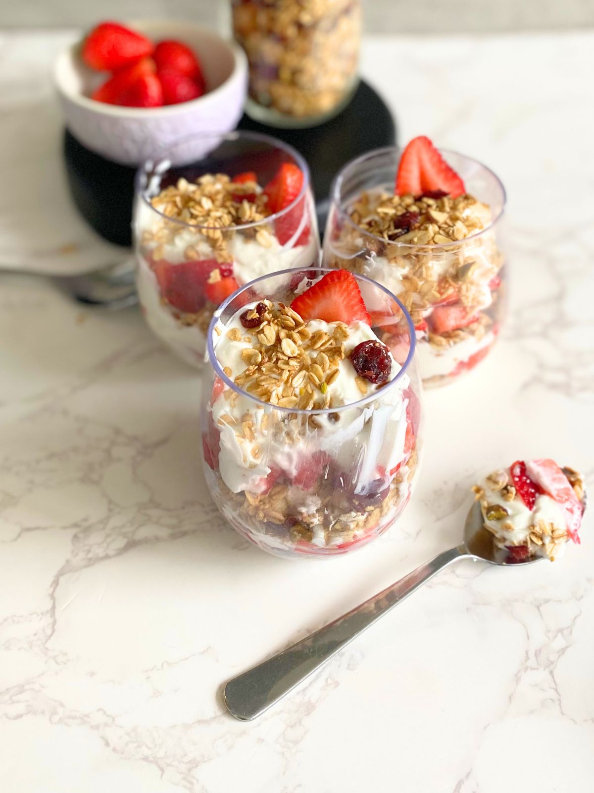 Christmas yogurt parfait with a bite taken out of it and yogurt on a spoon