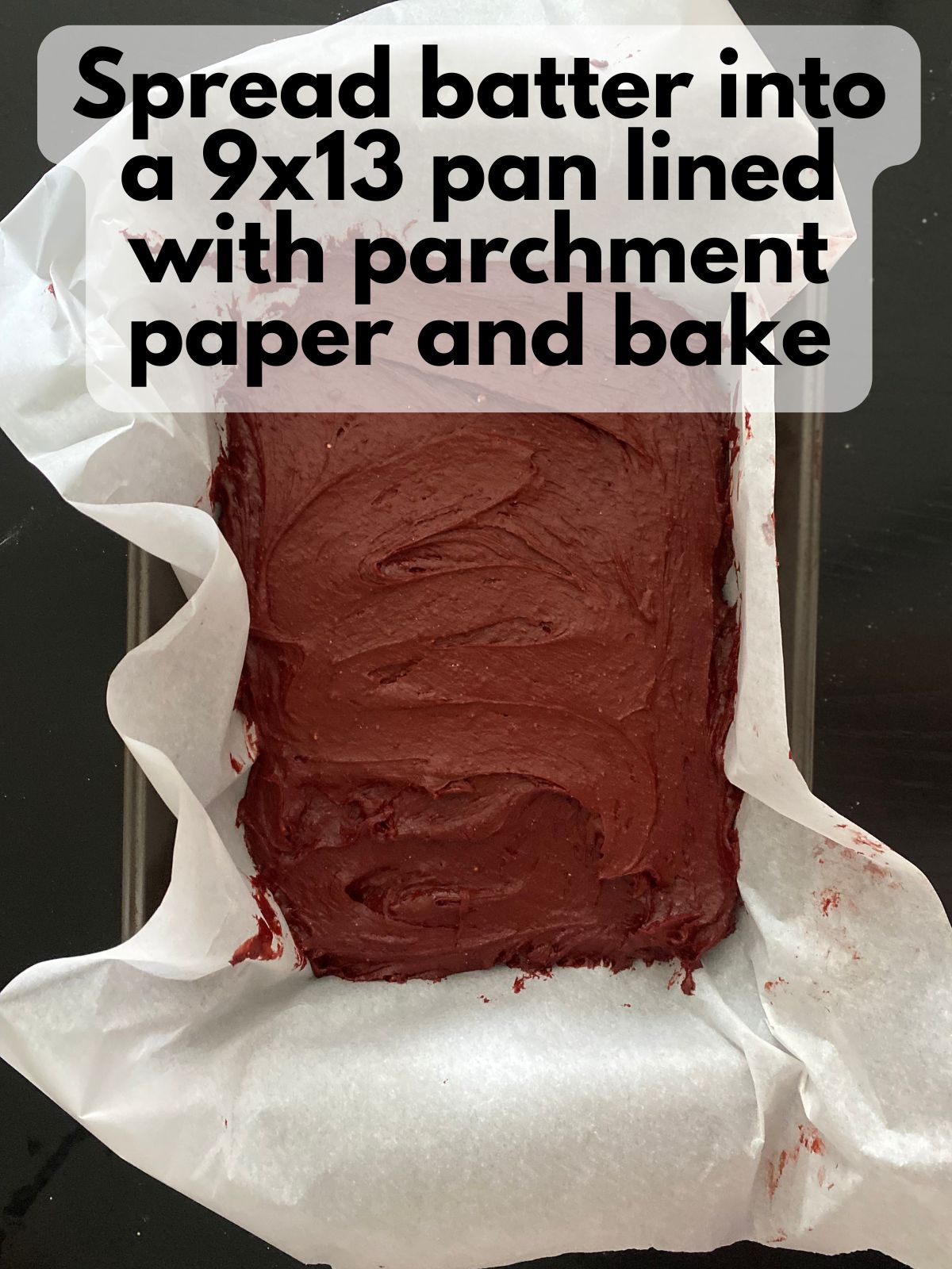 red velvet brownie batter spread in a pan