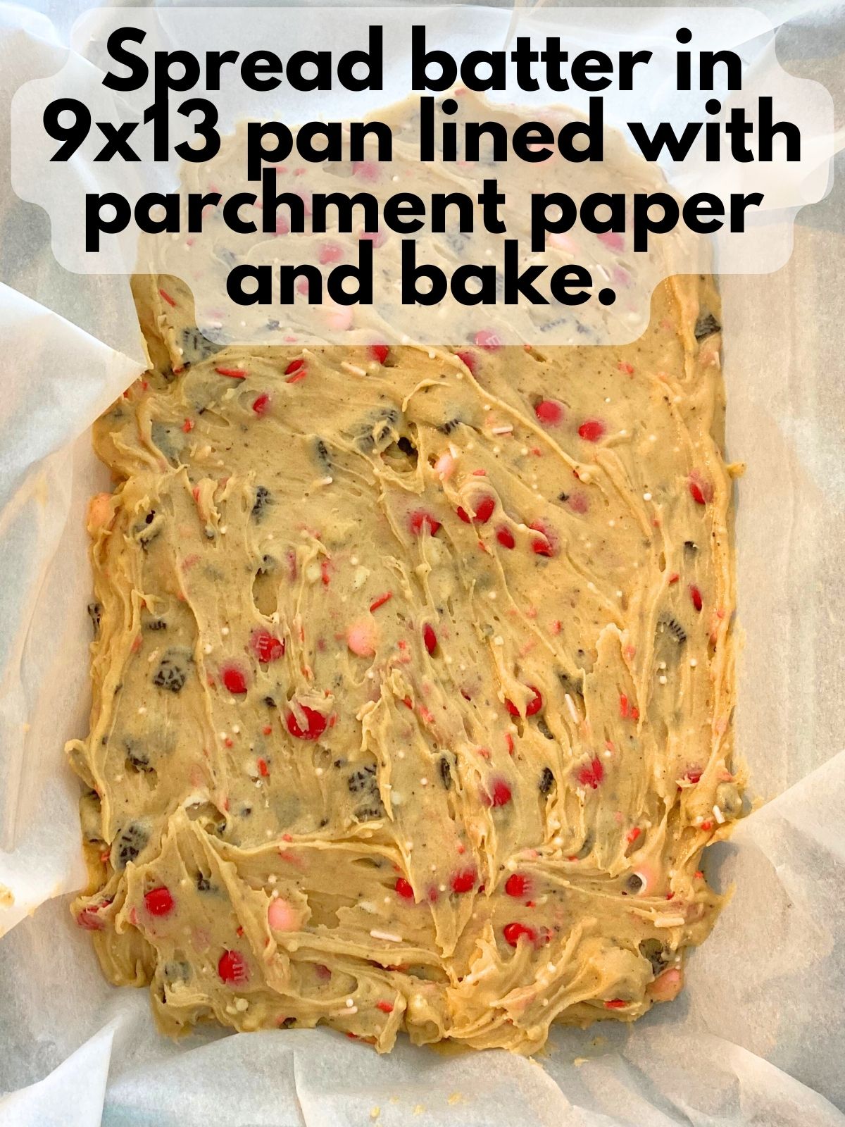 blondie batter spread in a 9x13 pan lined with parchment paper