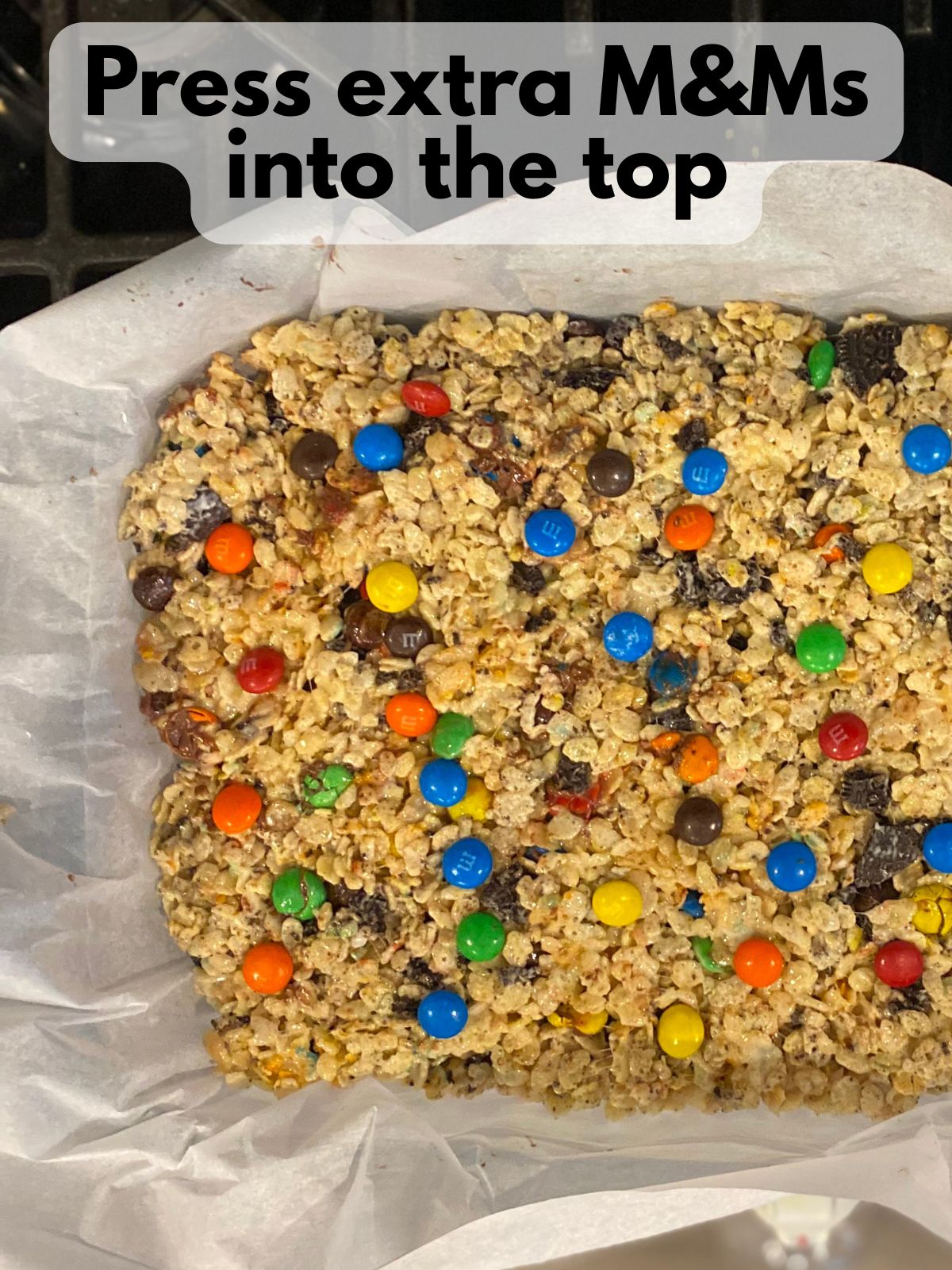 M&M oreo rice krispie treats in a pan with extra M&Ms pressed on top