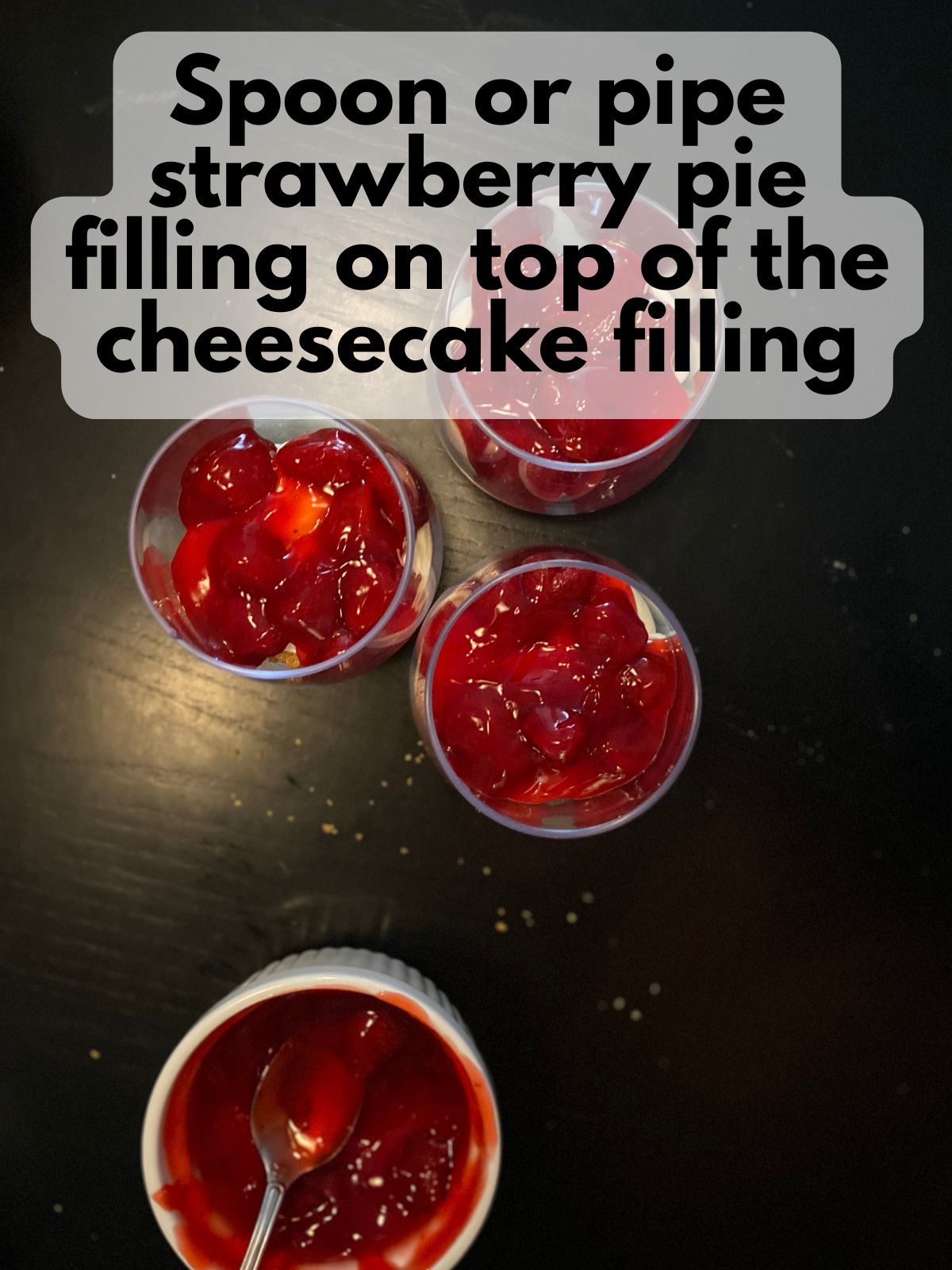 strawberry pie filling layered on top of cheesecake cups