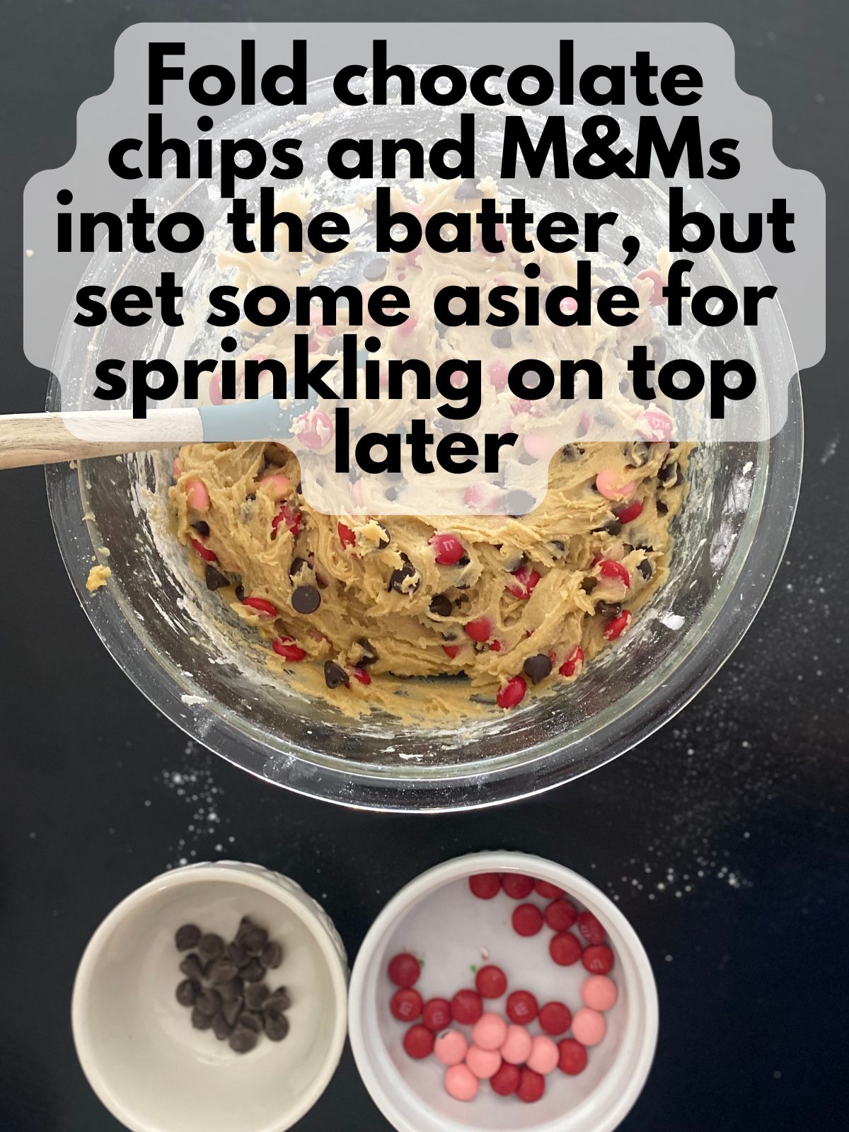 heart cookie cake dough with M&Ms and chocolate chips folded in, some are kept aside