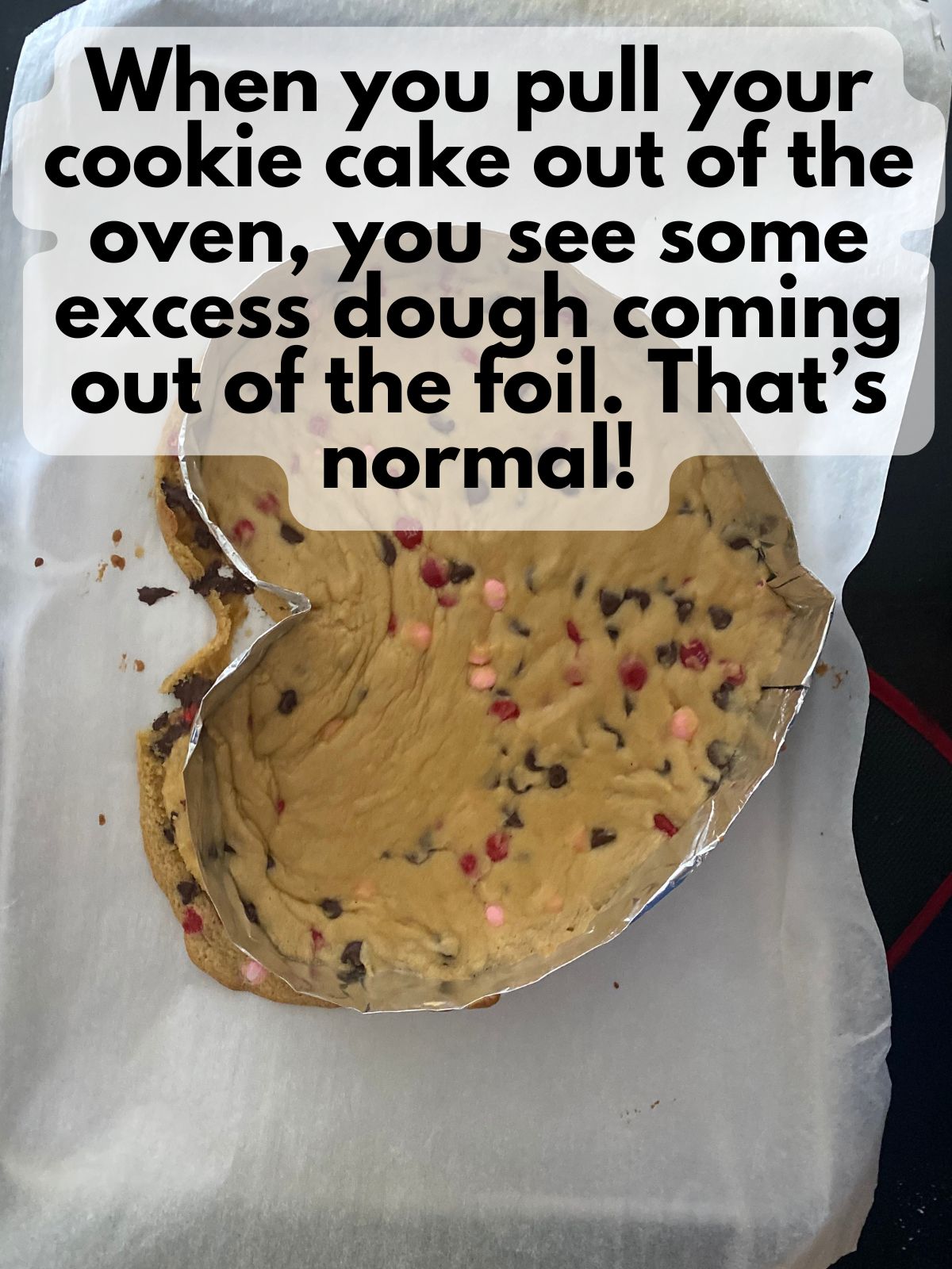 partially baked dough in an aluminum foil heart where some of the dough has leaked out around the heart
