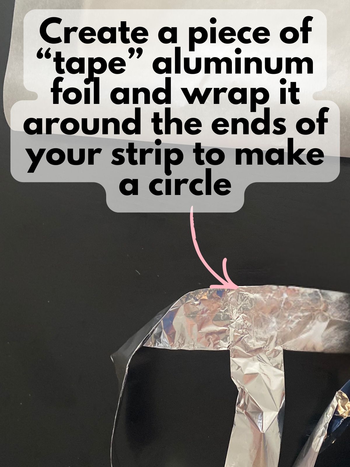 a piece of aluminum foil being wrapped around the edges of a long strip of aluminum foil to form a circle