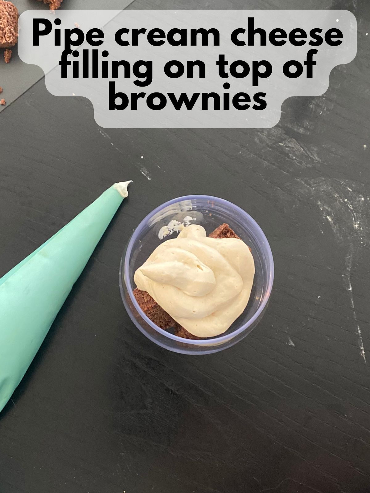cream cheese filling piped on top of brownie cubes
