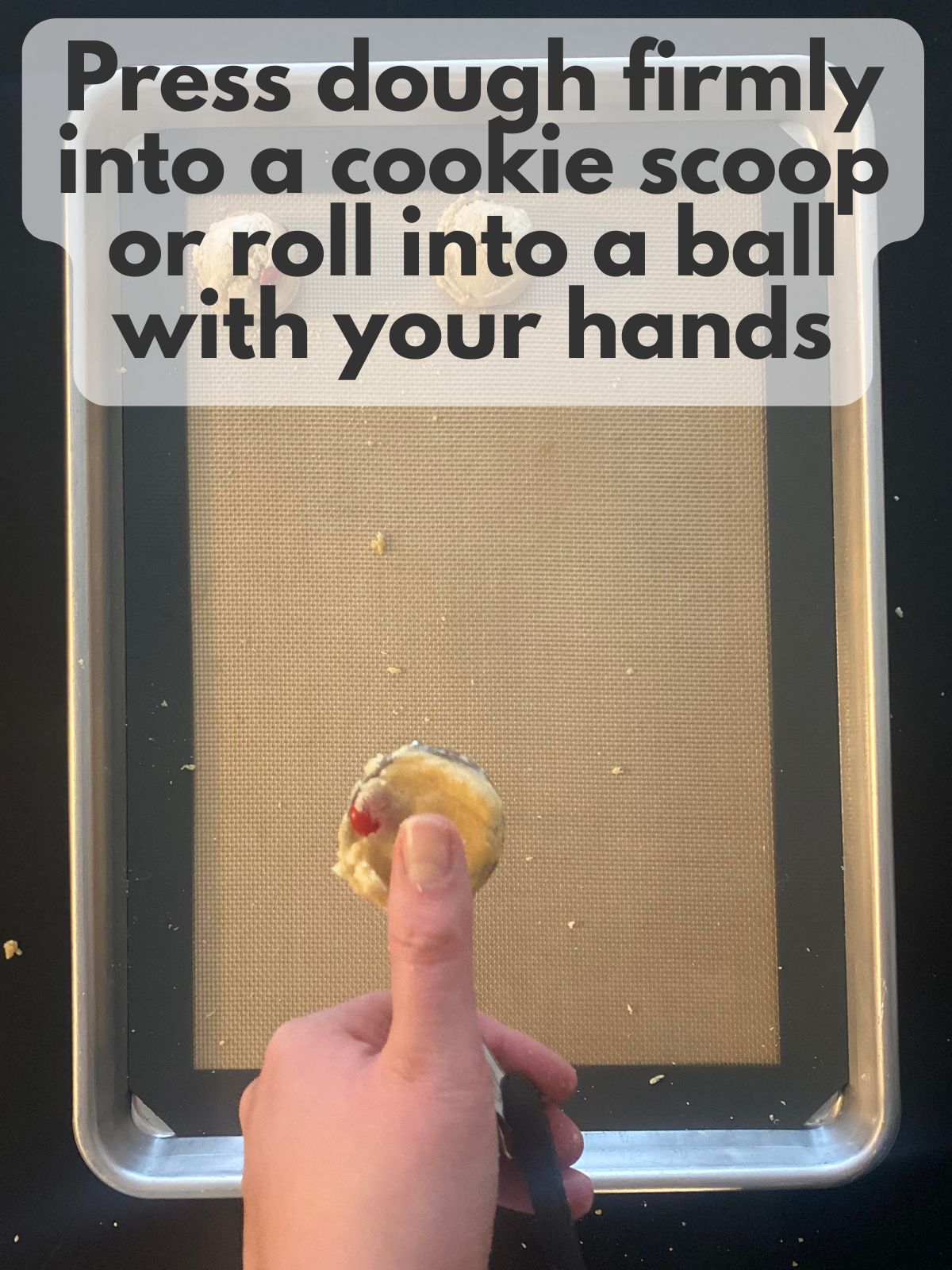 pressing cookie dough into a cookie scoop