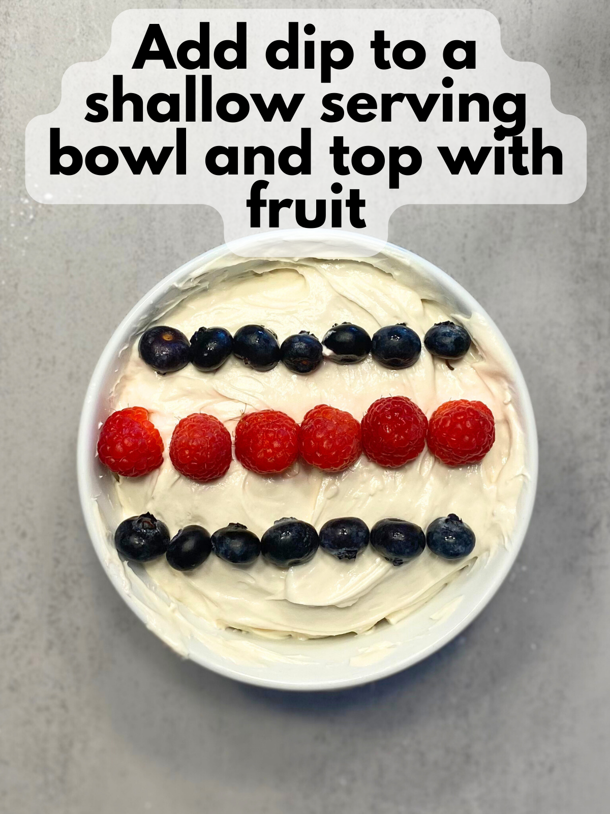 cheesecake fruit dip in a serving bowl with fruit on top