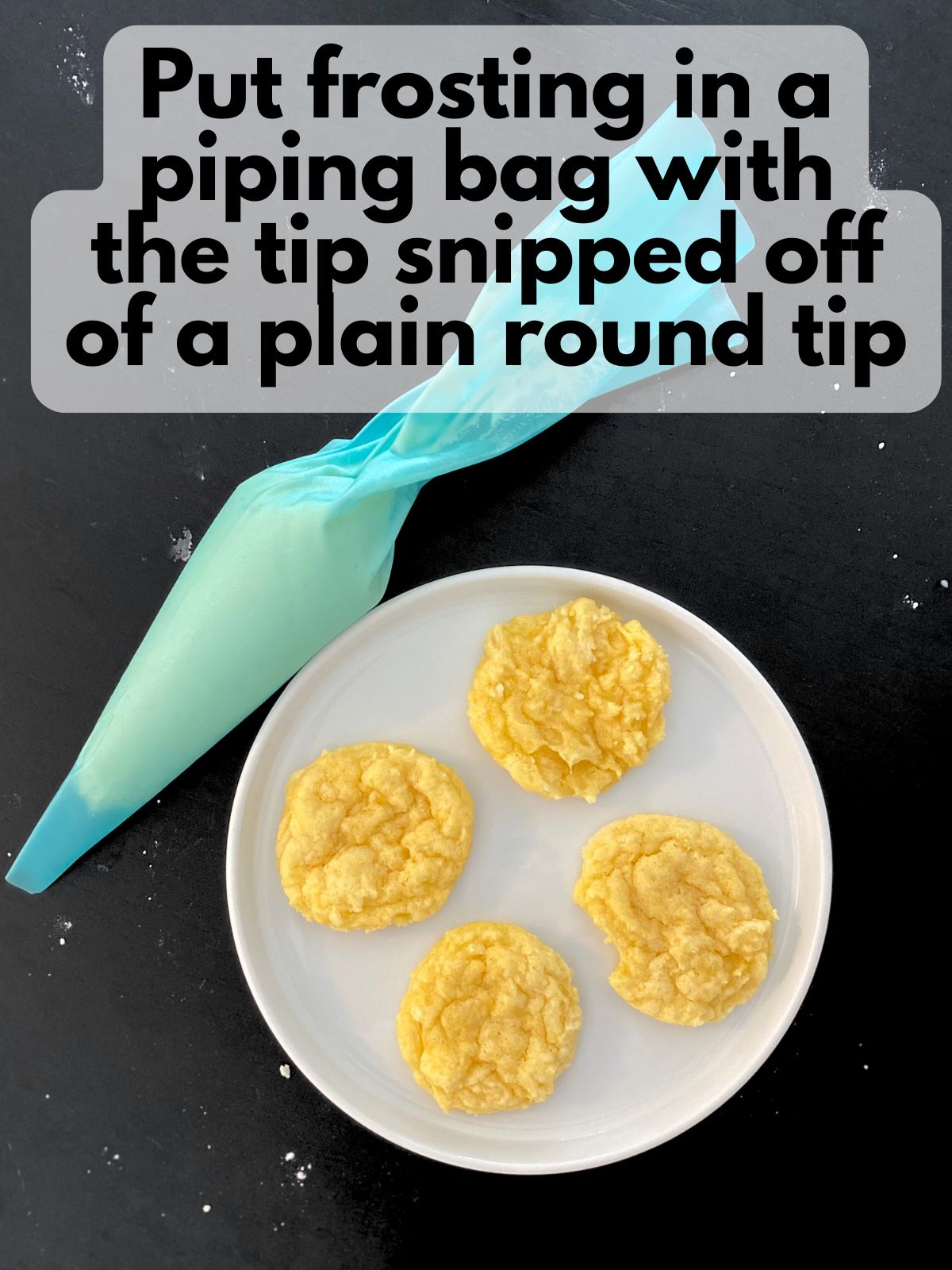 vanilla frosting in a piping bag next to a plate of lemon cake mix cookies