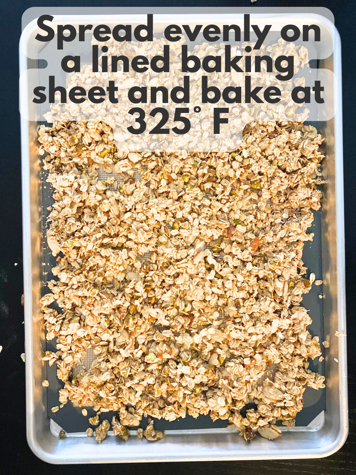 granola ingredients spread on a baking sheet