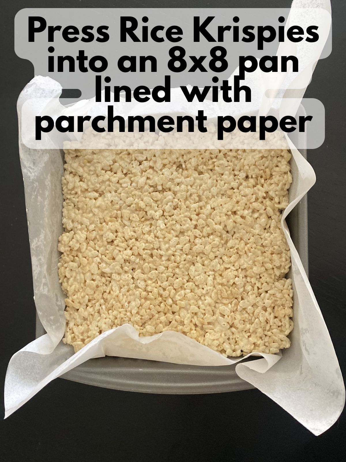 brown butter rice krispie treats pressed into an 8x8 pan lined with parchment paper