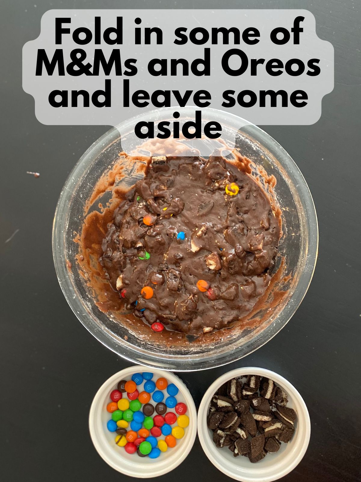 brownie batter with M&Ms and Oreos folded in and some M&Ms and Oreos kept aside