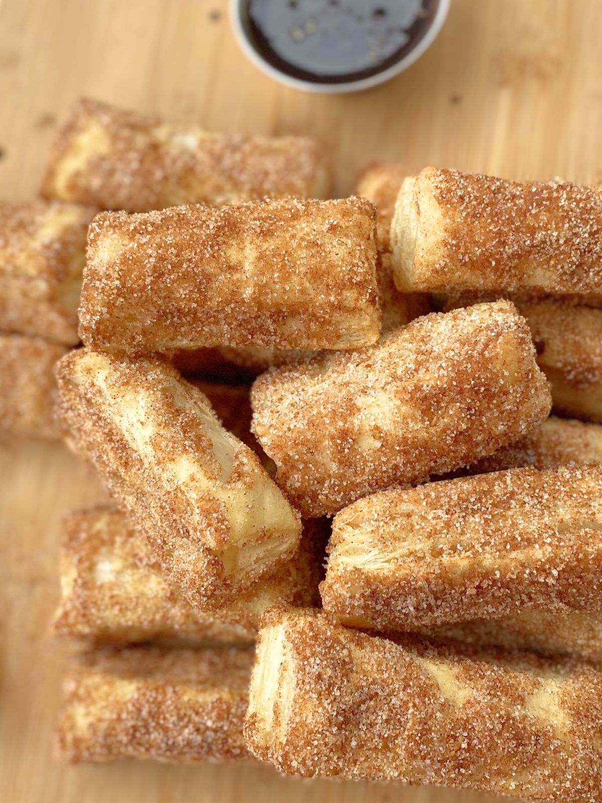 baked churro bites on a platter with chocolate dipping sauce