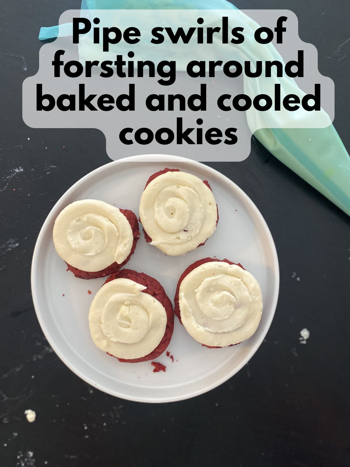 cream cheese piped onto cooled red velvet cake mix cookies