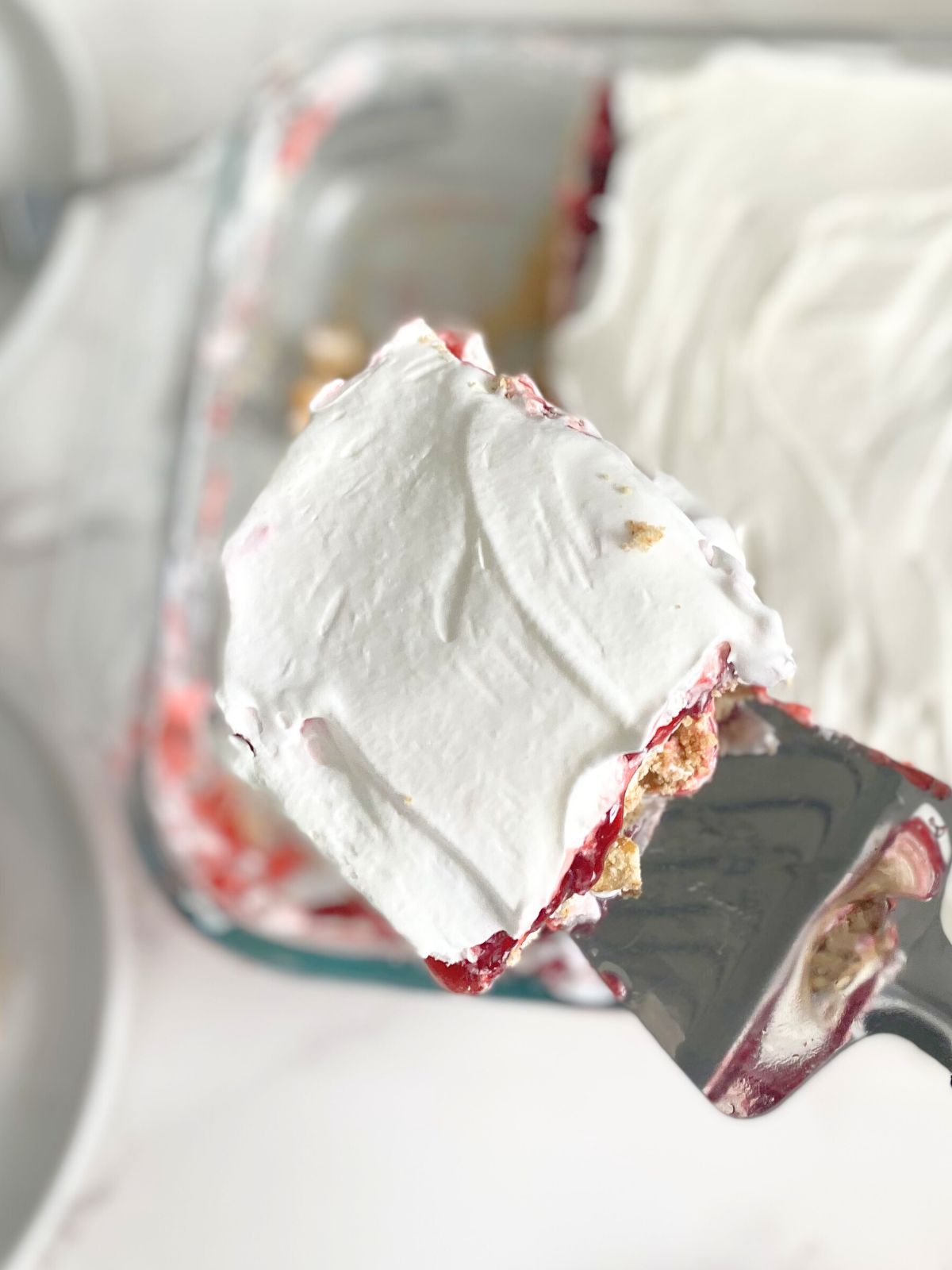 slice of strawberry lasagna being lifted out of the pan