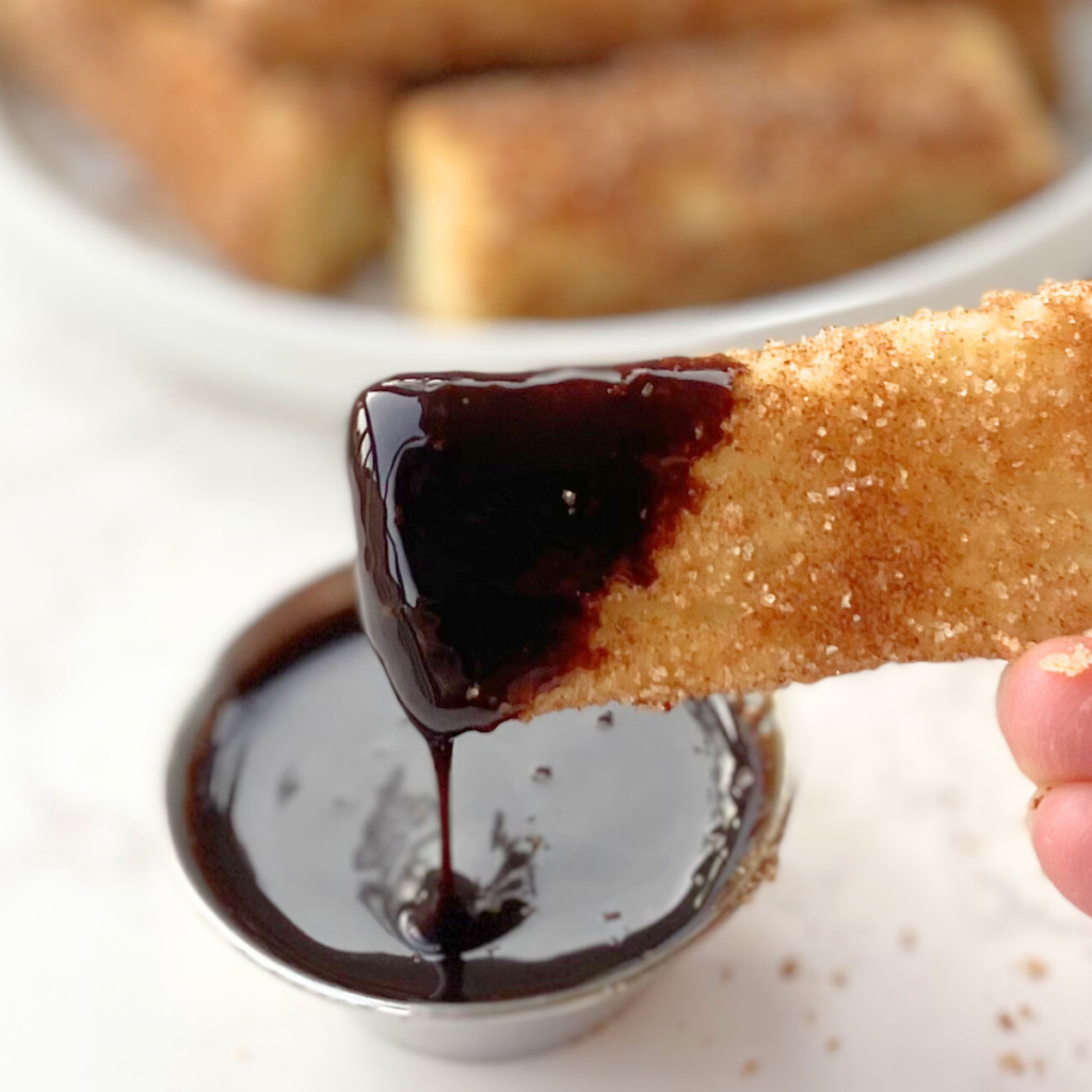 air fryer churro bite dipped in chocolate