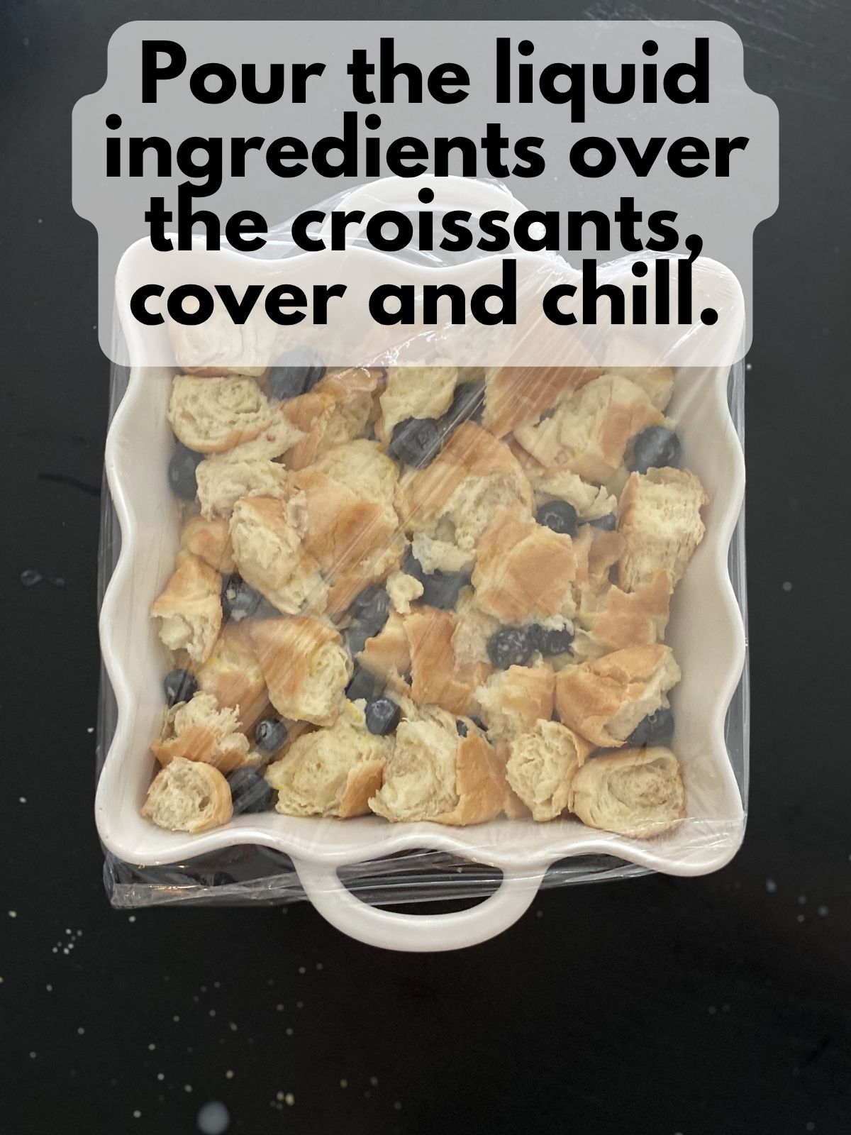 croissants soaked in custard covered in plastic wrap