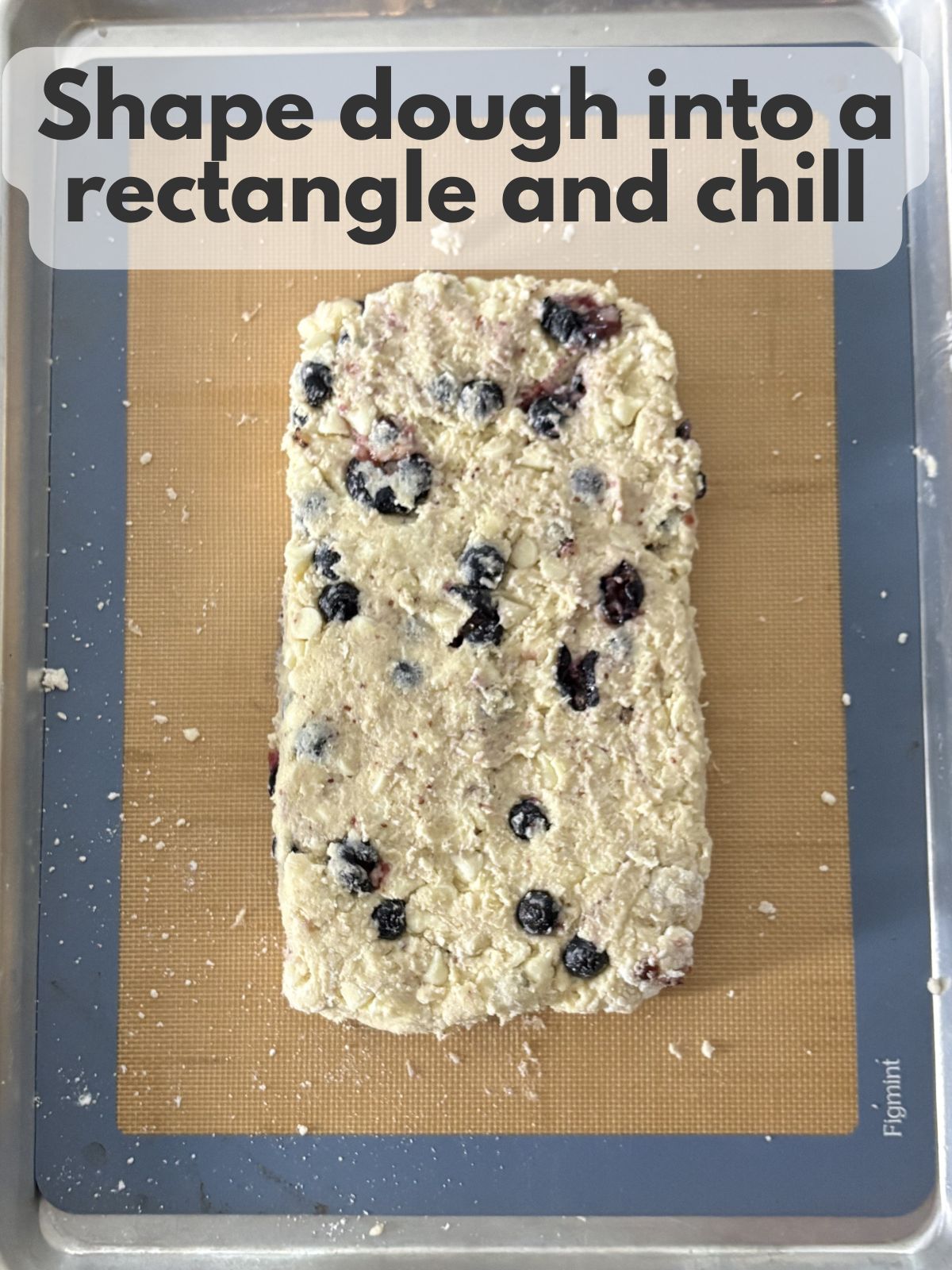 shaped blueberry white chocolate scone dough chilling on a lined baking sheet
