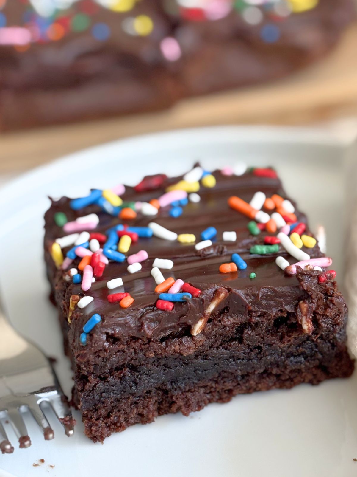 brownie with chocolate ganache and sprinkles on a plate
