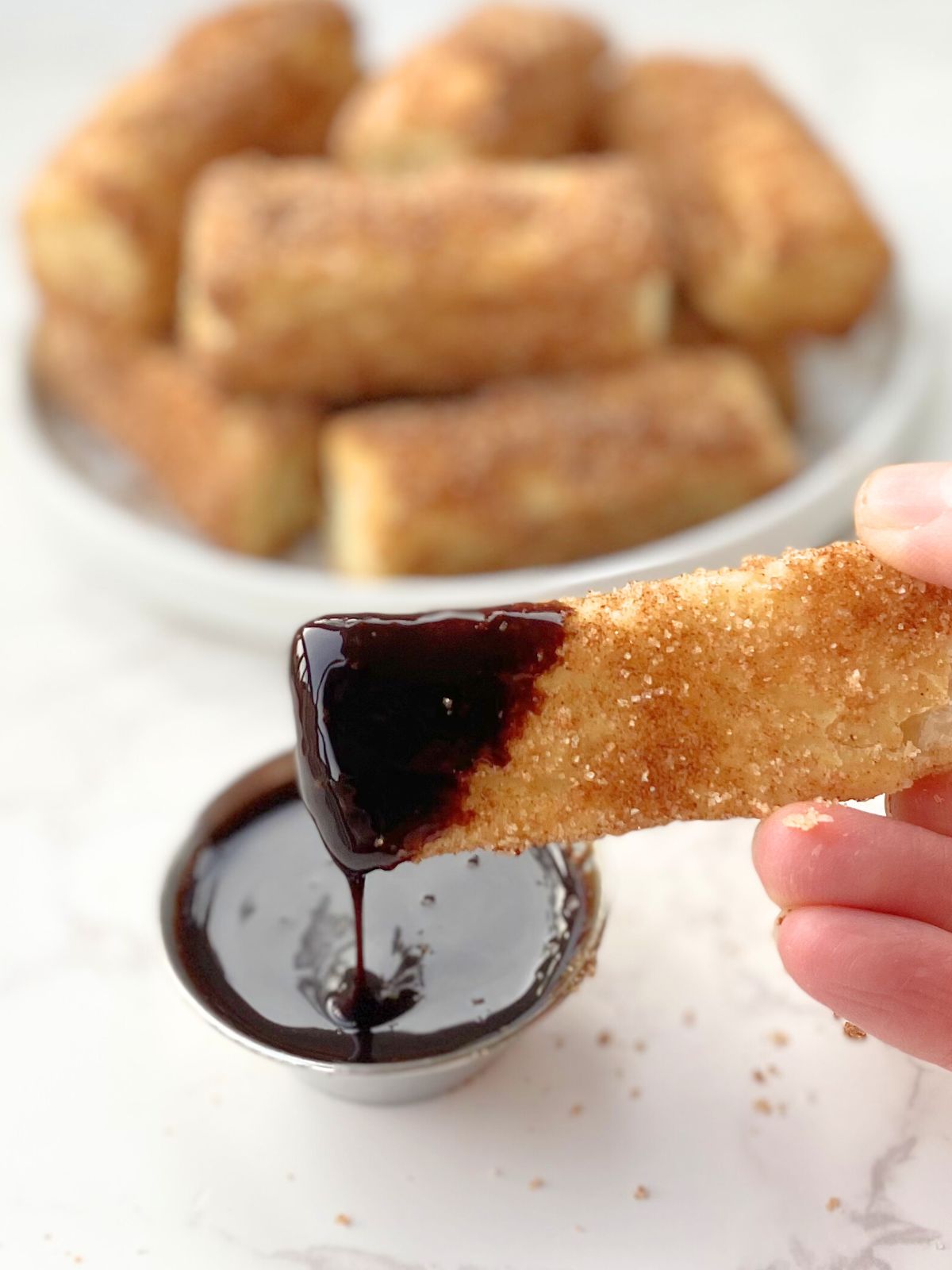 air fryer churro bite dipped in chocolate