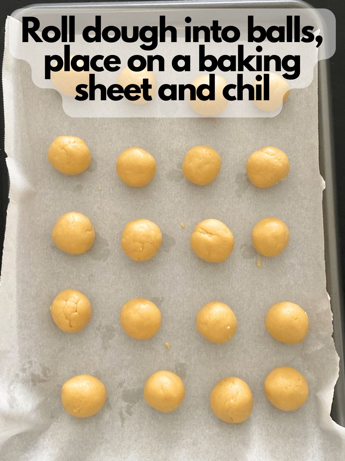 lemon Oreo ball dough rolled into balls on a lined baking sheet