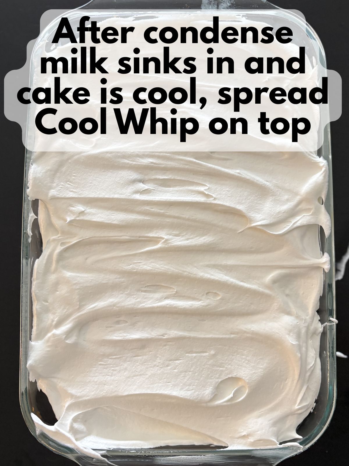 Cool Whip spread on top of Mexican Hot Chocolate poke cake