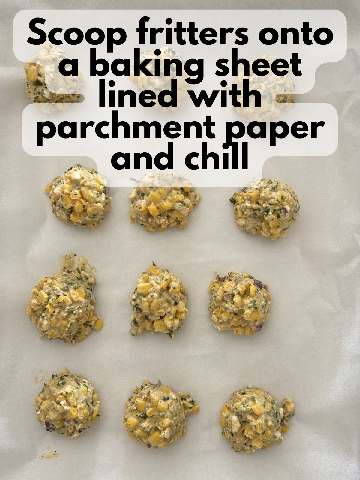 elote fritter dough chilling on a tray lined with parchment paper