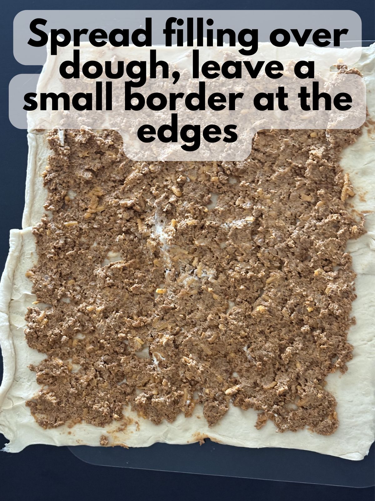 creamy taco filling spread on crescent dough