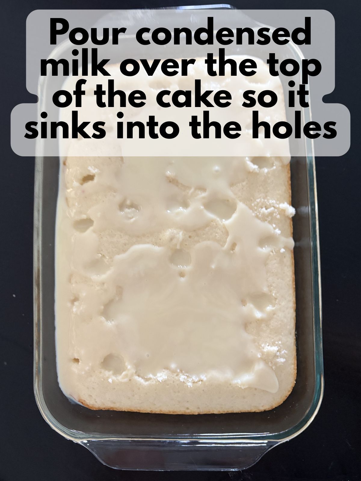 condensed milk poured into the holes of a poke cake