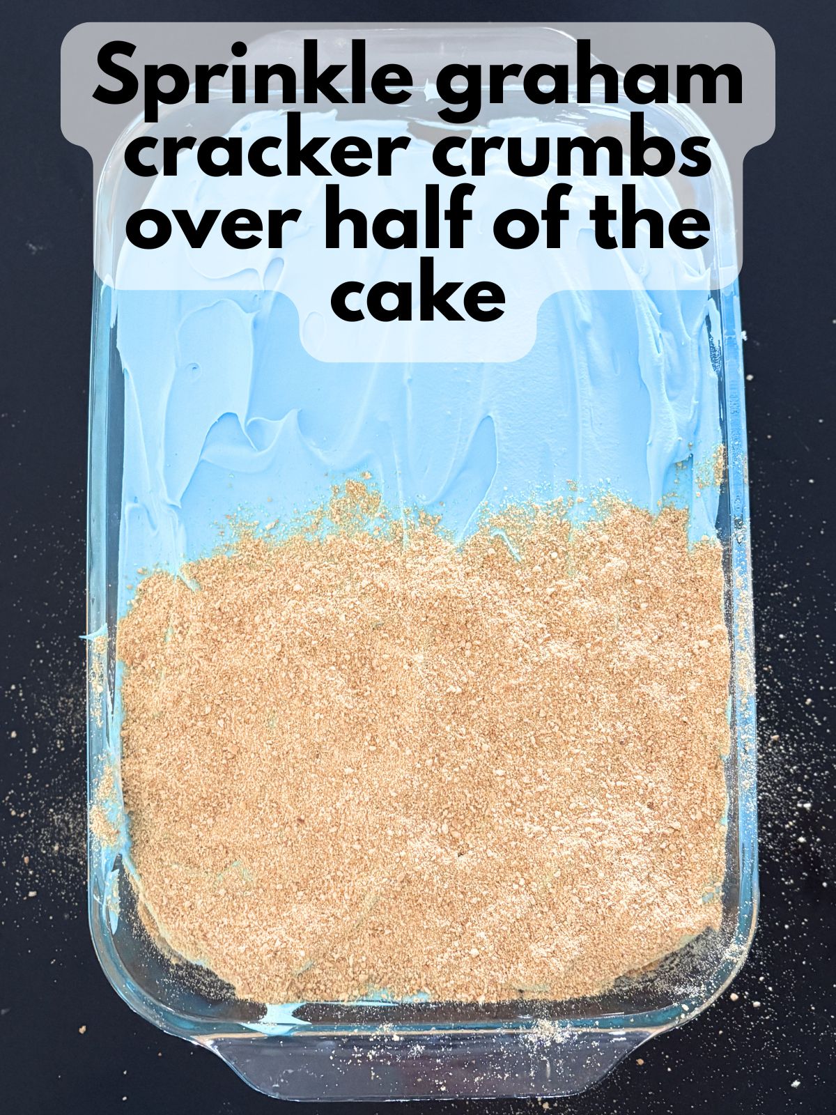 graham cracker crumbs spread over half of poke cake