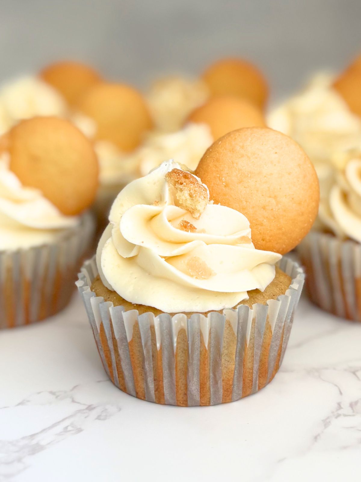 banana pudding cupcakes sitting on a marble countertop