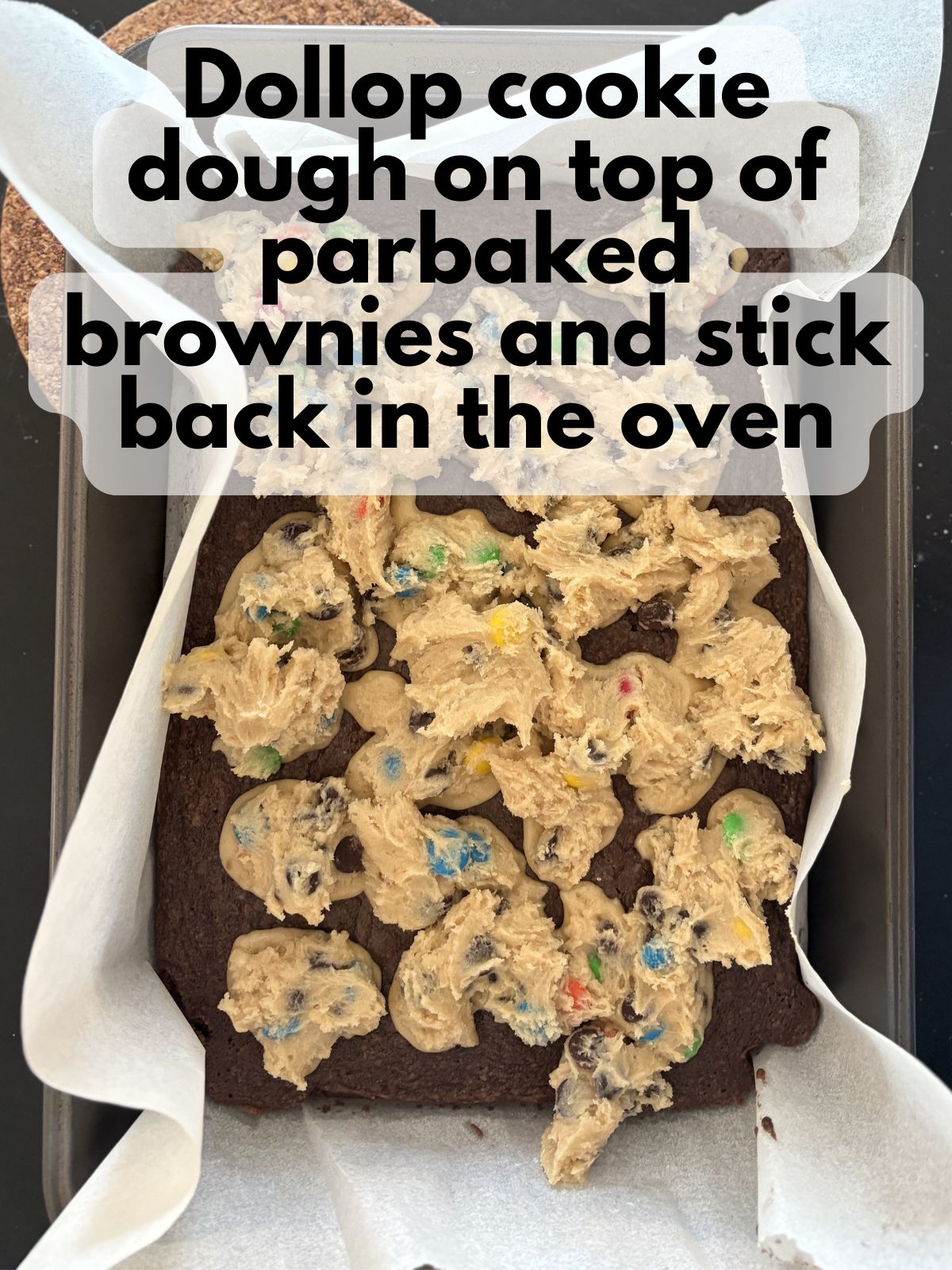 cookie dough dolloped on top of parbaked brownies