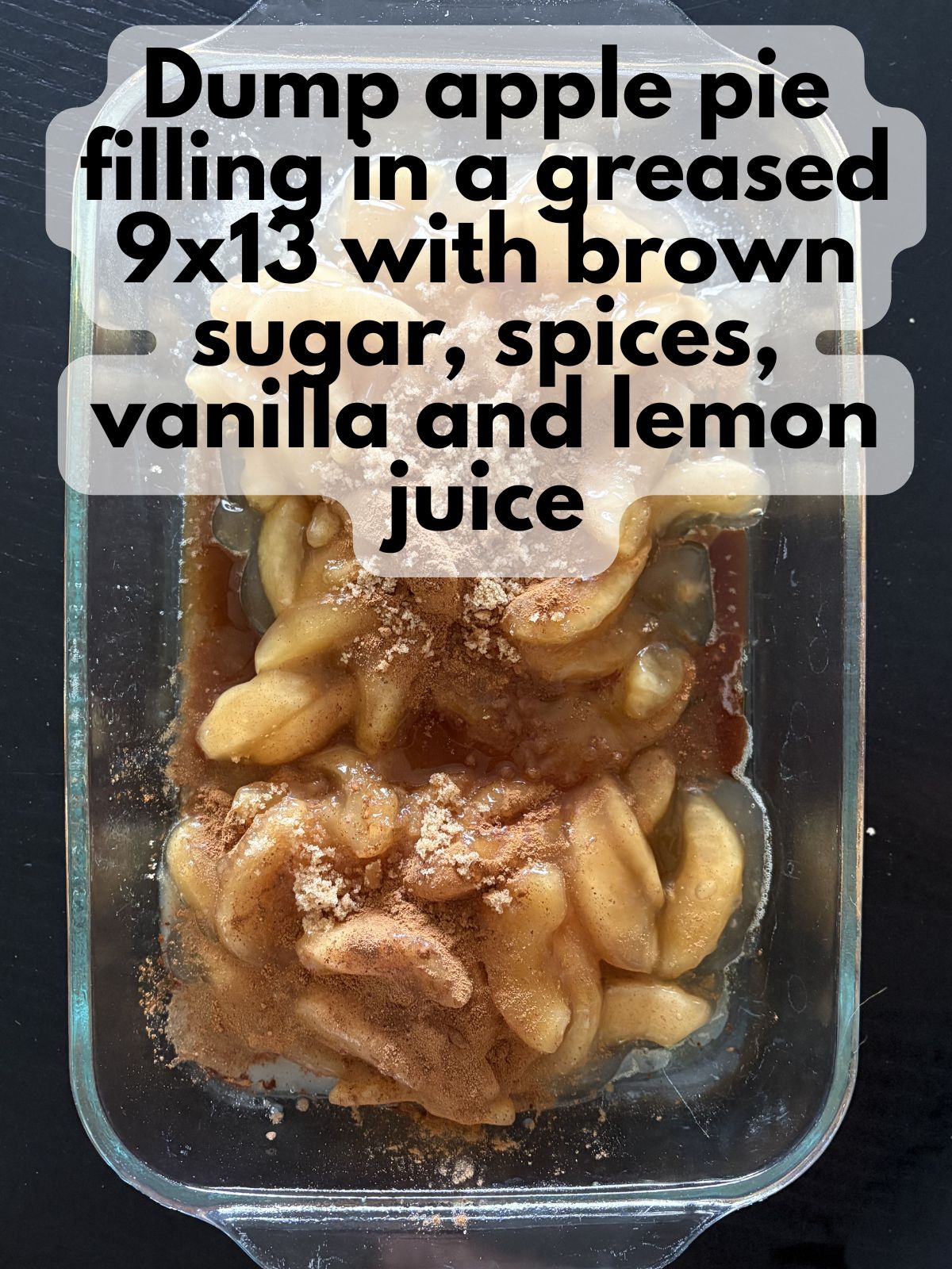 apple pie filling in a 9x13 baking dish with spices, brown sugar, vanilla and lemon juice