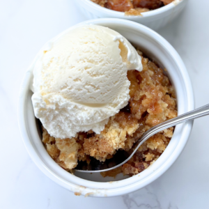 cake mix apple cobbler in a bowl topped with vanilla ice cream