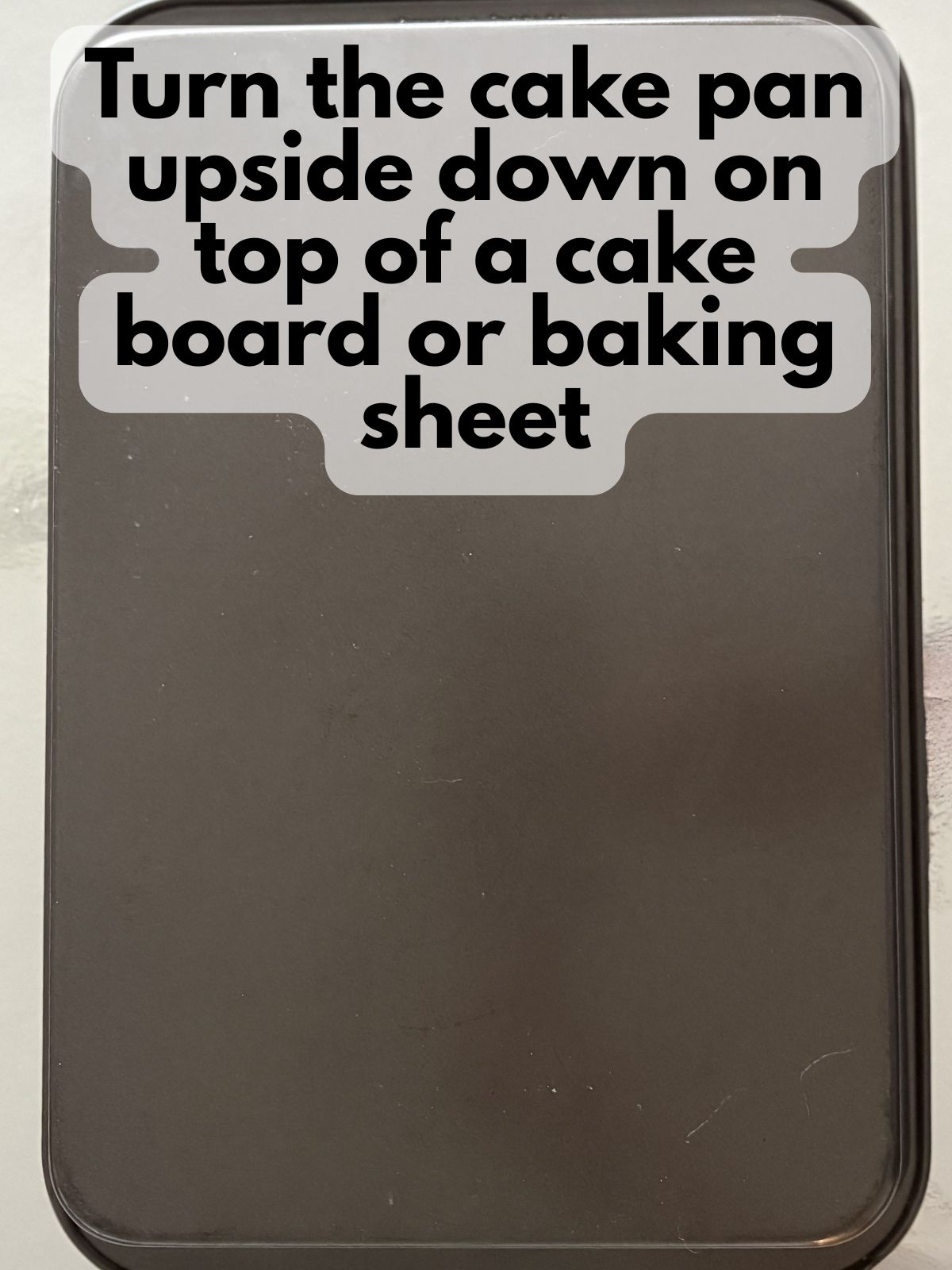 a 9x13 pan turned upside down on top of a cake board