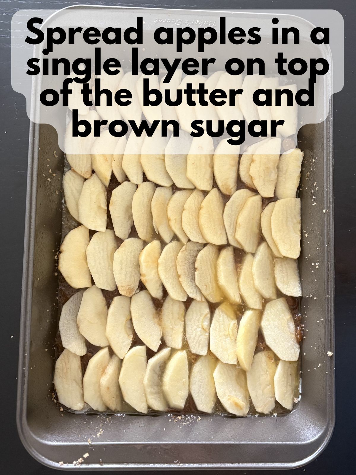 apple slices on top of melted butter and brown sugar
