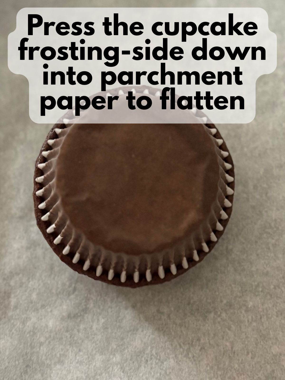 frosted cupcake pressed down into parchment paper