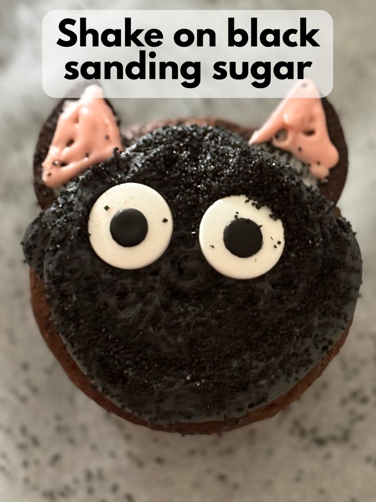 black sanding sugar on top of cat cupcakes