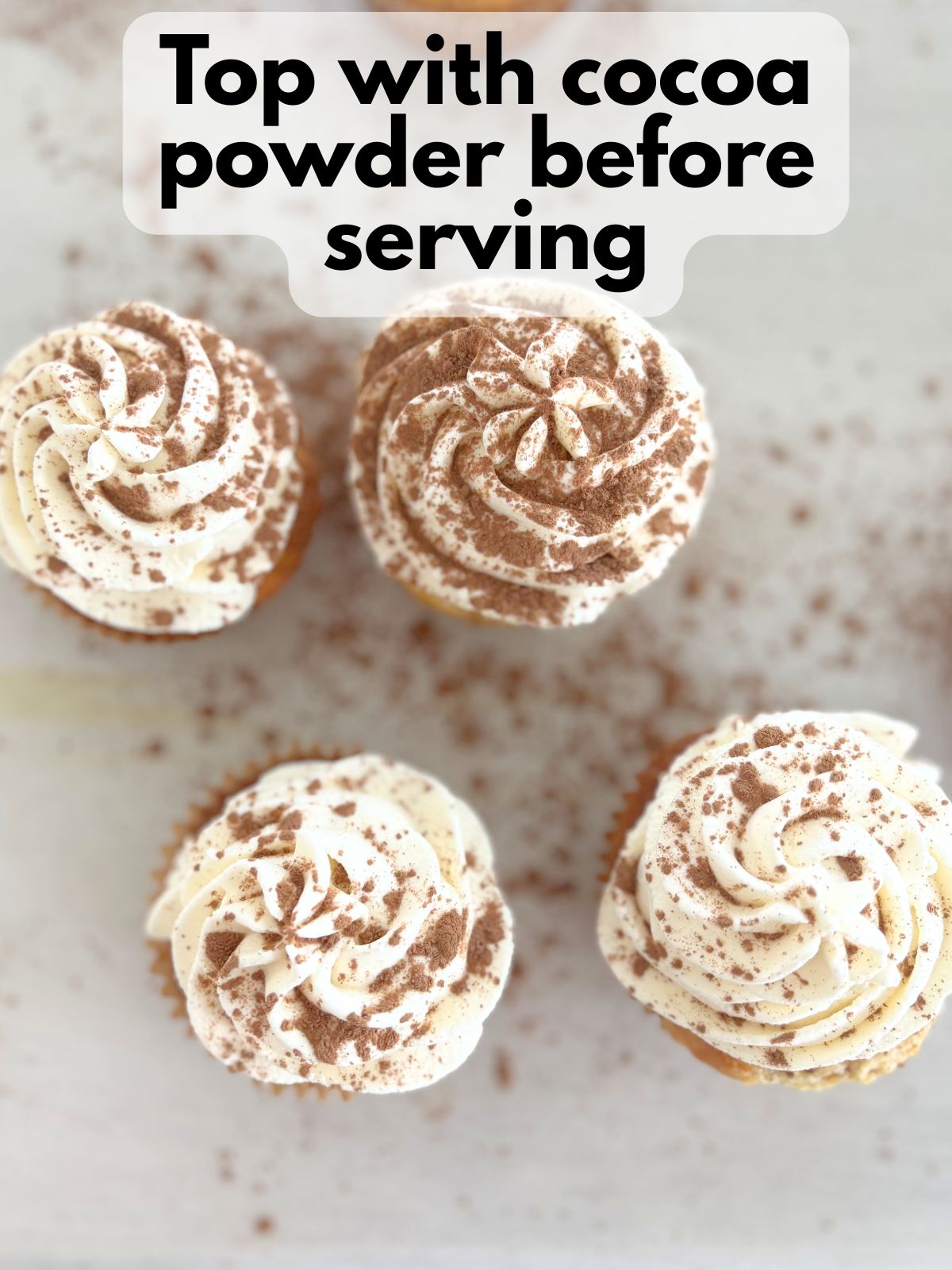 cocoa powder sprinkled over frosted tiramisu cupcakes