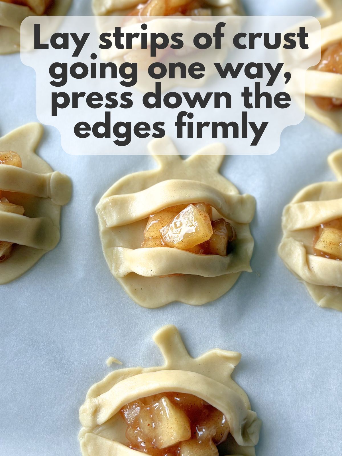 pie crust strips draped horizontally across mini apple pies