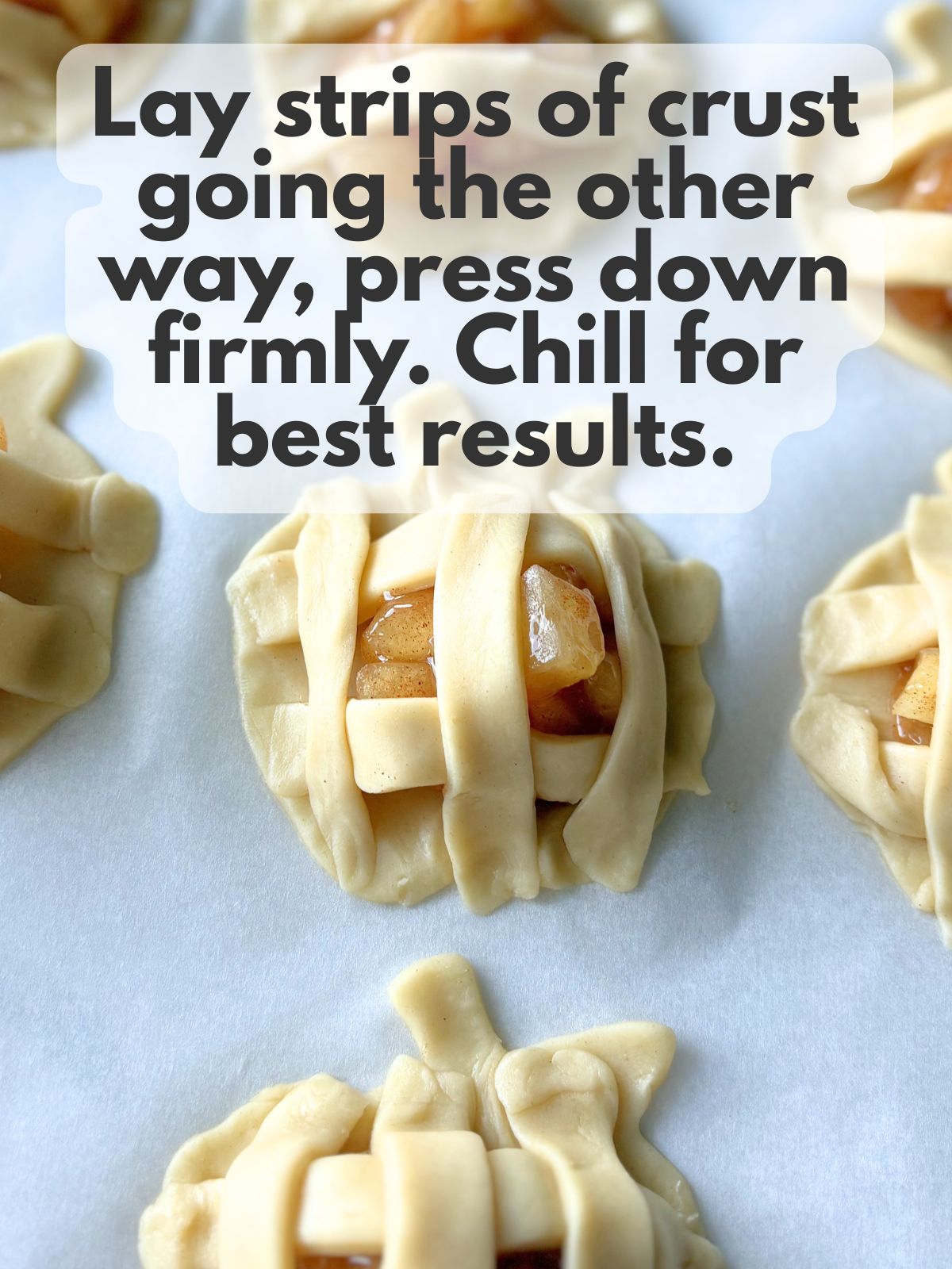 pie crust strips draped vertically over mini apple pies