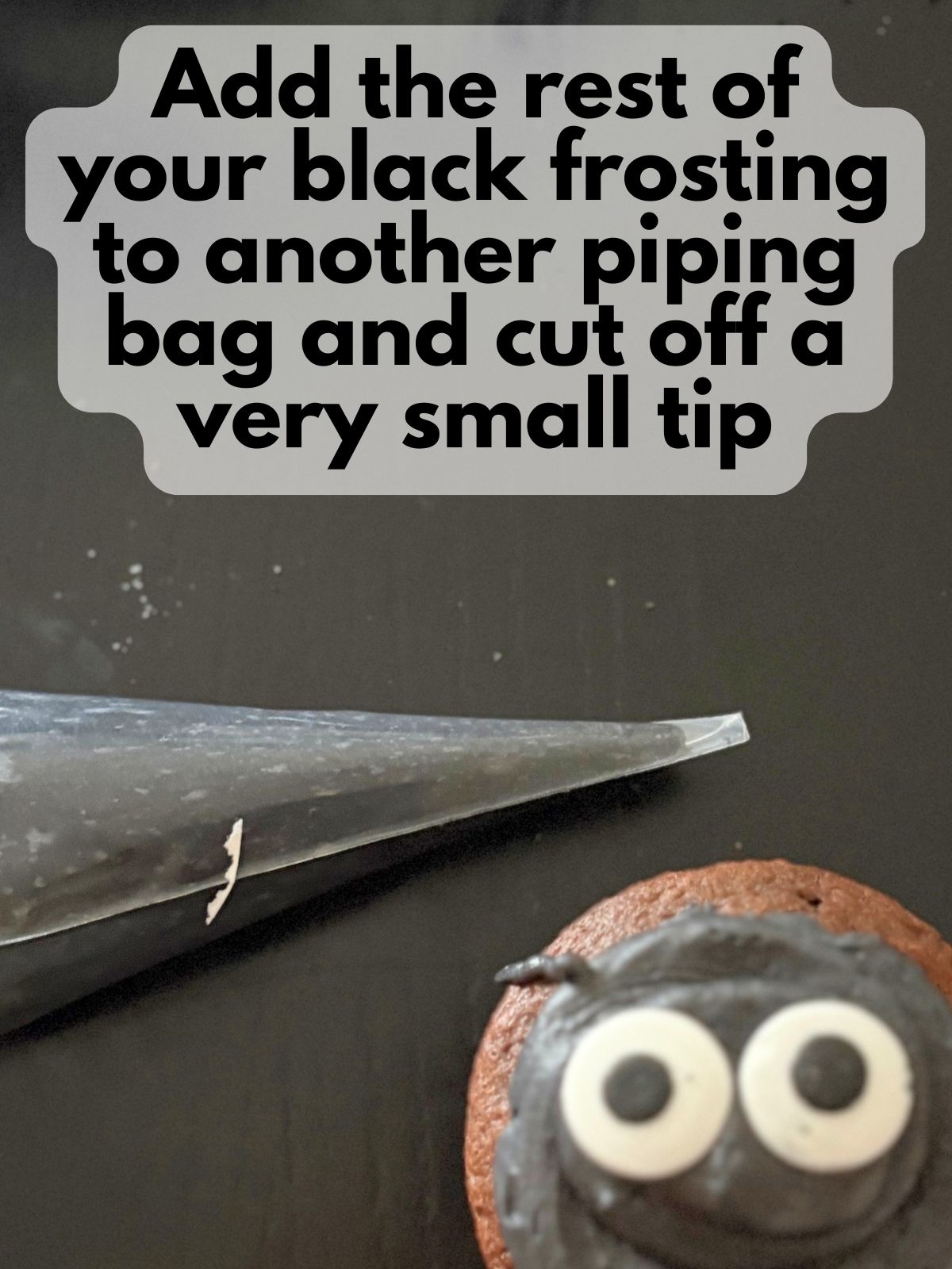 black frosting in a piping bag with just a tiny bit snipped off
