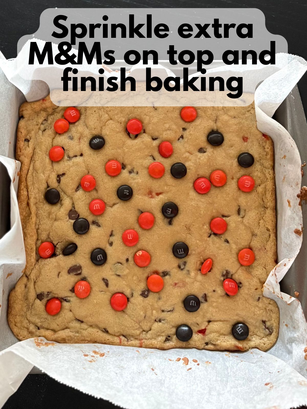 Par-baked cookie dough with extra M&Ms sprinkled on top