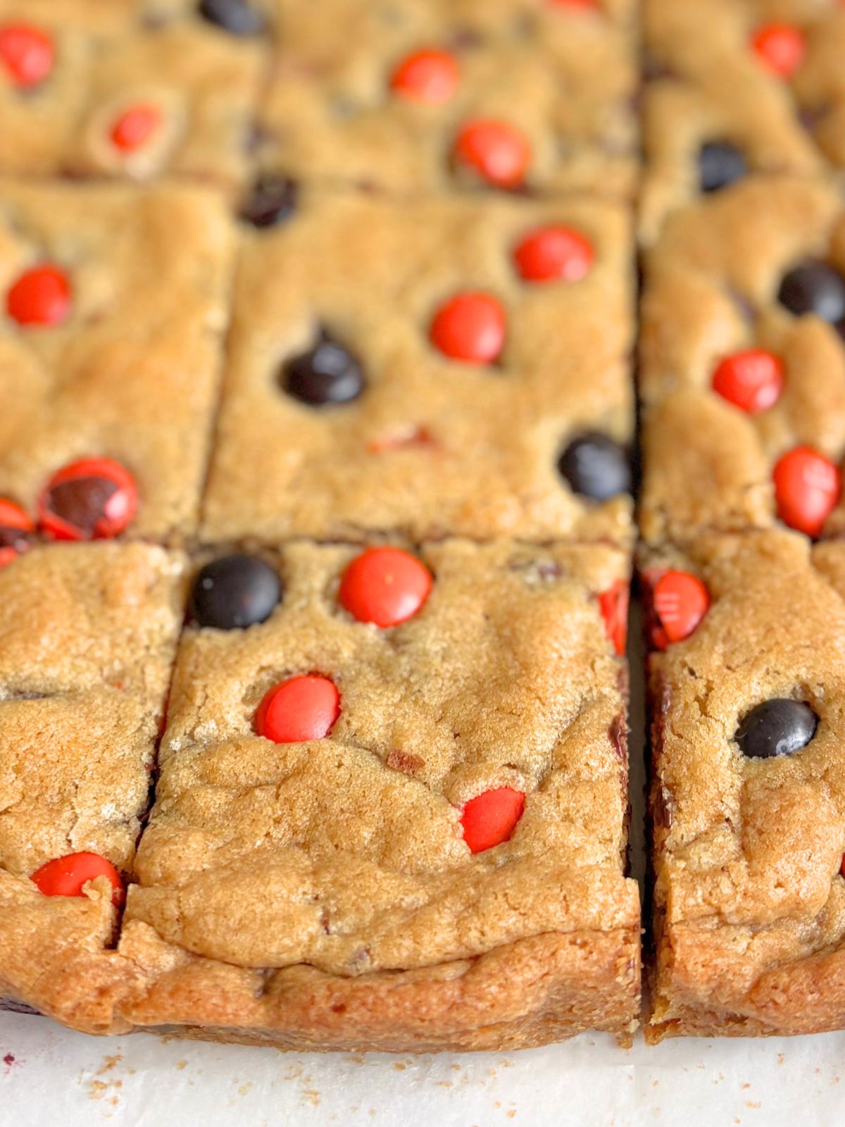 Halloween M& cookie bars sitting on parchment paper