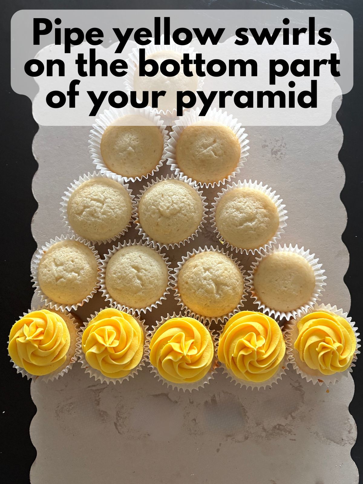 yellow frosting piped on the bottom row of the cupcake cake
