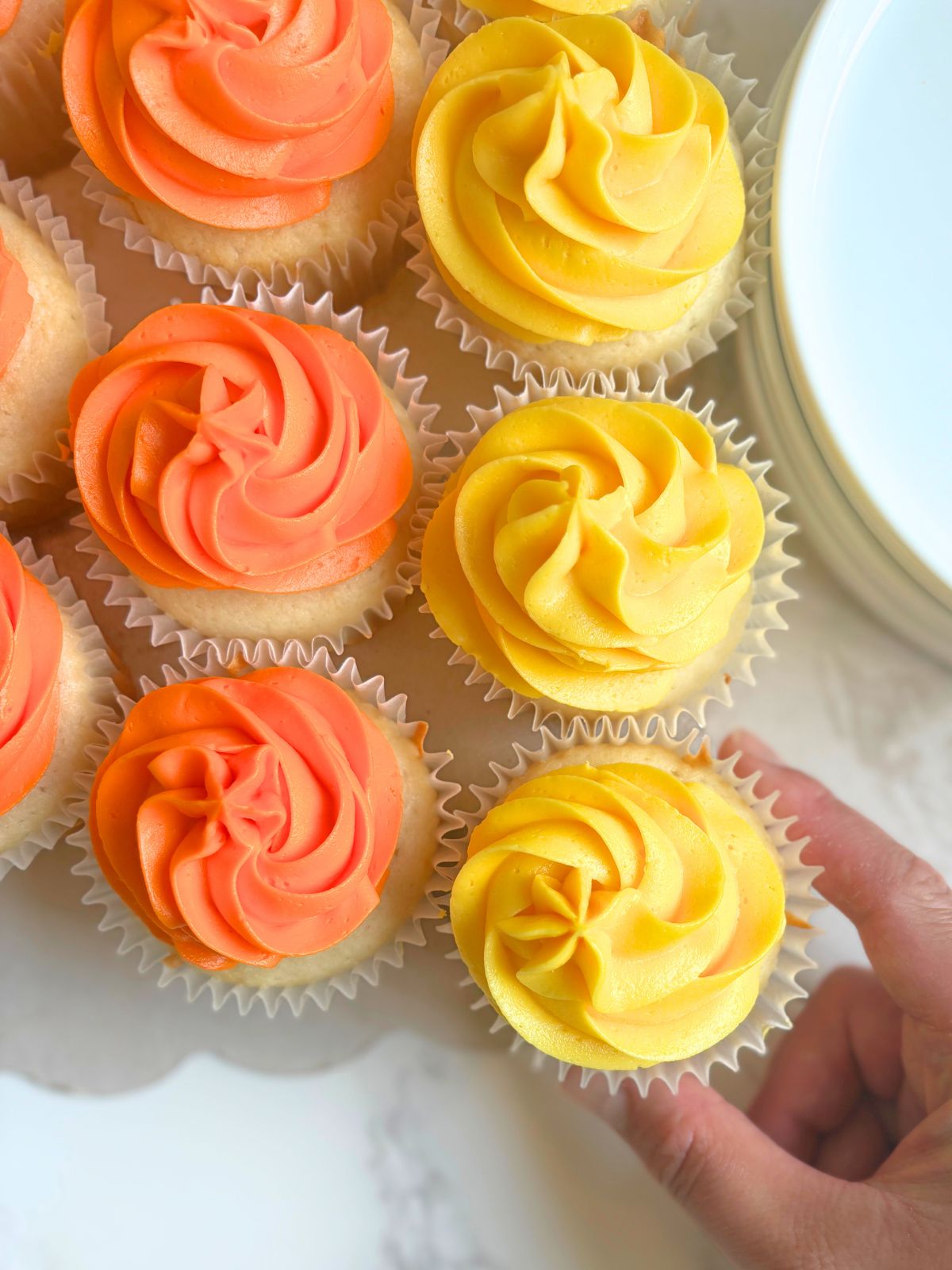 a cupcake being pulled away from the cupcake cake