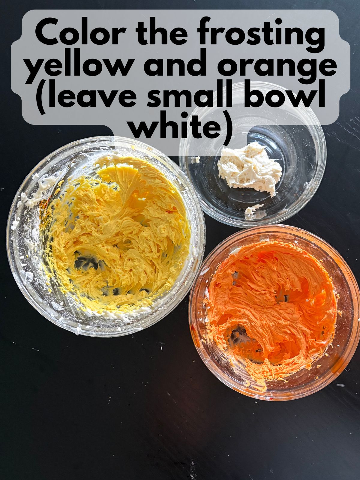 frosting colored orange and yellow in separate bowl
