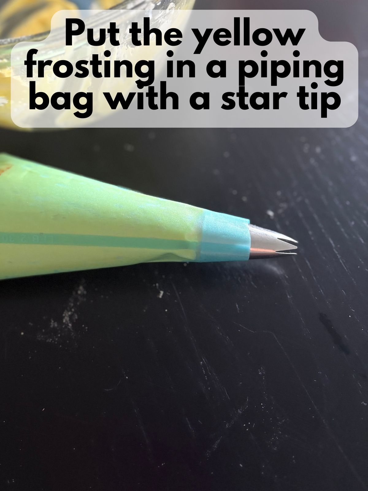 yellow buttercream in a piping bag with a star tip